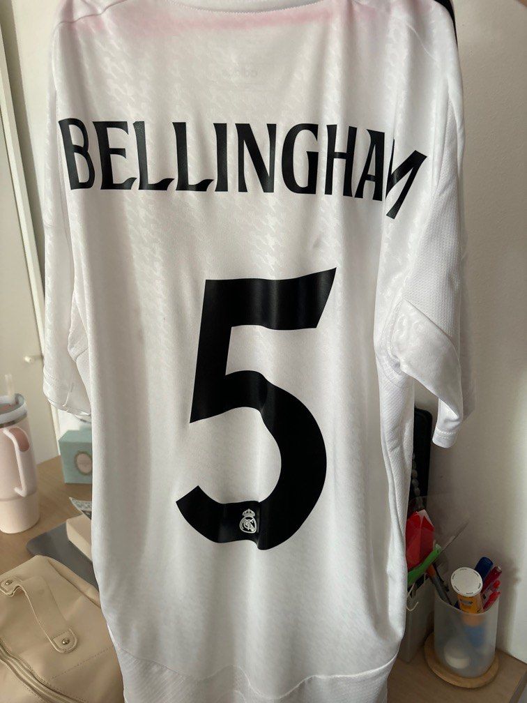 Real Madrid Fan Jersey 24/25 Season with Bellingham personalised name & number (Category: Activewear) located in Singapore. Submitted by fatin_strawberry (Listing ID 1326897175, Image 2). Description: Authentic and original Real Madrid fan jersey with personalised Bellingham’s name & number. Selling this at $50 .