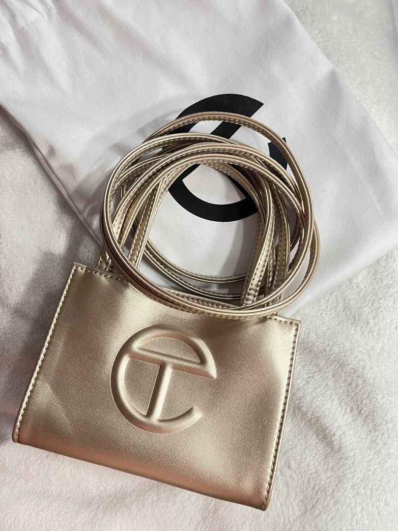 TELFAR Small Shopping Bag in Gold (Category: Luxury Bags & Wallets) located in Cainta. Submitted by sydkyn (Listing ID 1327418910, Image 2). Description: • brand: TELFAR • dimensions: Height - 4 3/4”, Width - 6 5/8”, Depth - 3”, Strap Drop - 21”, Handle Drop -4 3/4” • condition: 10/10 • note: NEVER BEEN USED. bought from the US. packaged in a drawstring bag with screen-printed logo. currently sold out in the official TELFAR website 😳 the iconic 