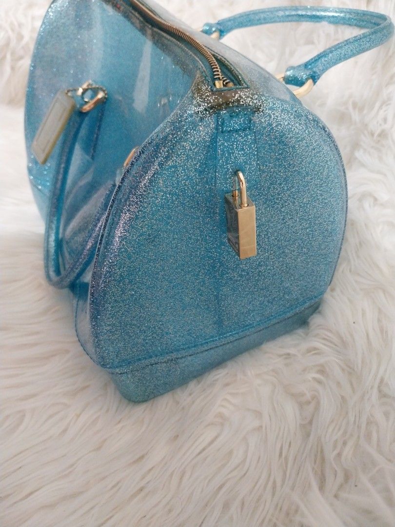 Furla Blue Glitter Candy Boston Bag (RARE) (Category: Luxury Bags & Wallets) located in Mandaluyong City. Submitted by ksjocana (Listing ID 1327956587, Image 3). Description: Original Retail Price: US $248/P13,650 Selling all my Authentic Furla bags from hubby during my Furla "phase" Needs a new home. With tag and lock. Join the rubber bag craze that has taken the fashion world by storm. This Blue glitter Furla tote is the accessory to have on a 