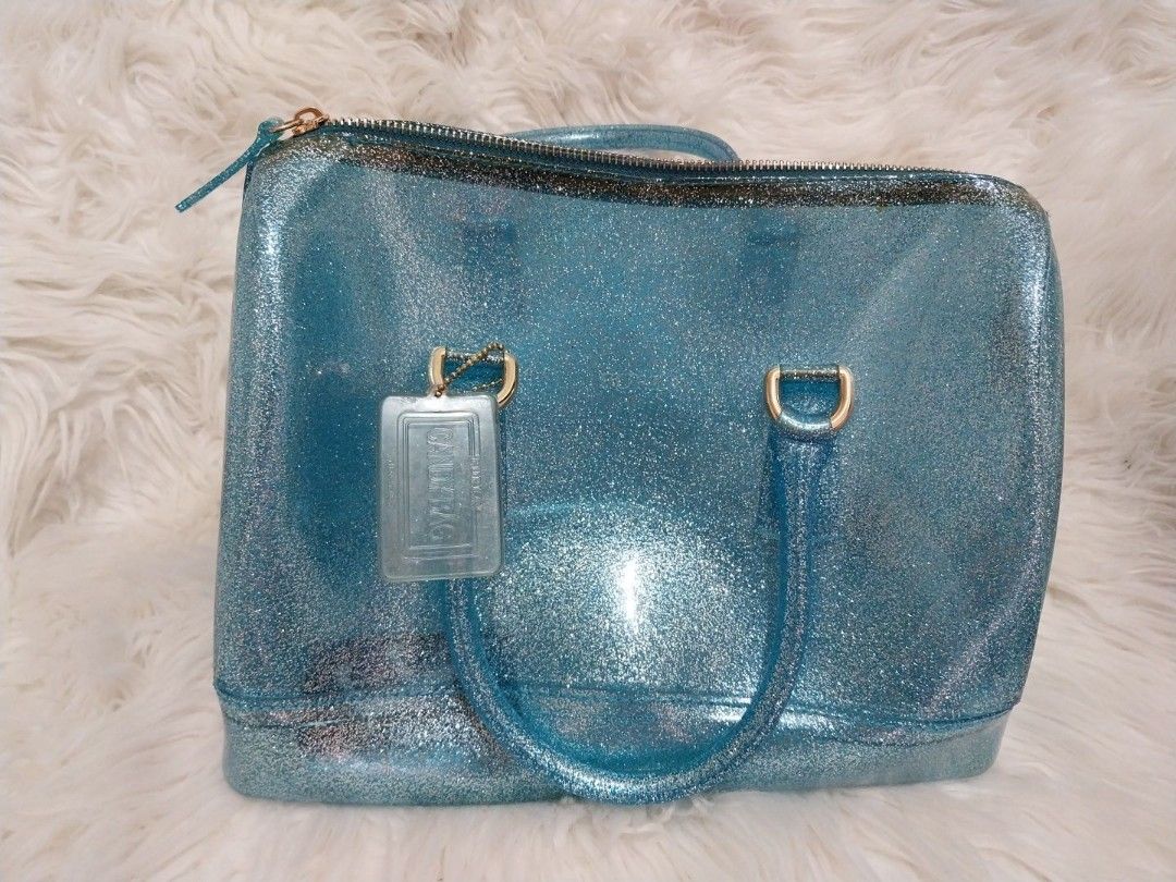 Furla Blue Glitter Candy Boston Bag (RARE) (Category: Luxury Bags & Wallets) located in Mandaluyong City. Submitted by ksjocana (Listing ID 1327956587, Image 2). Description: Original Retail Price: US $248/P13,650 Selling all my Authentic Furla bags from hubby during my Furla "phase" Needs a new home. With tag and lock. Join the rubber bag craze that has taken the fashion world by storm. This Blue glitter Furla tote is the accessory to have on a 
