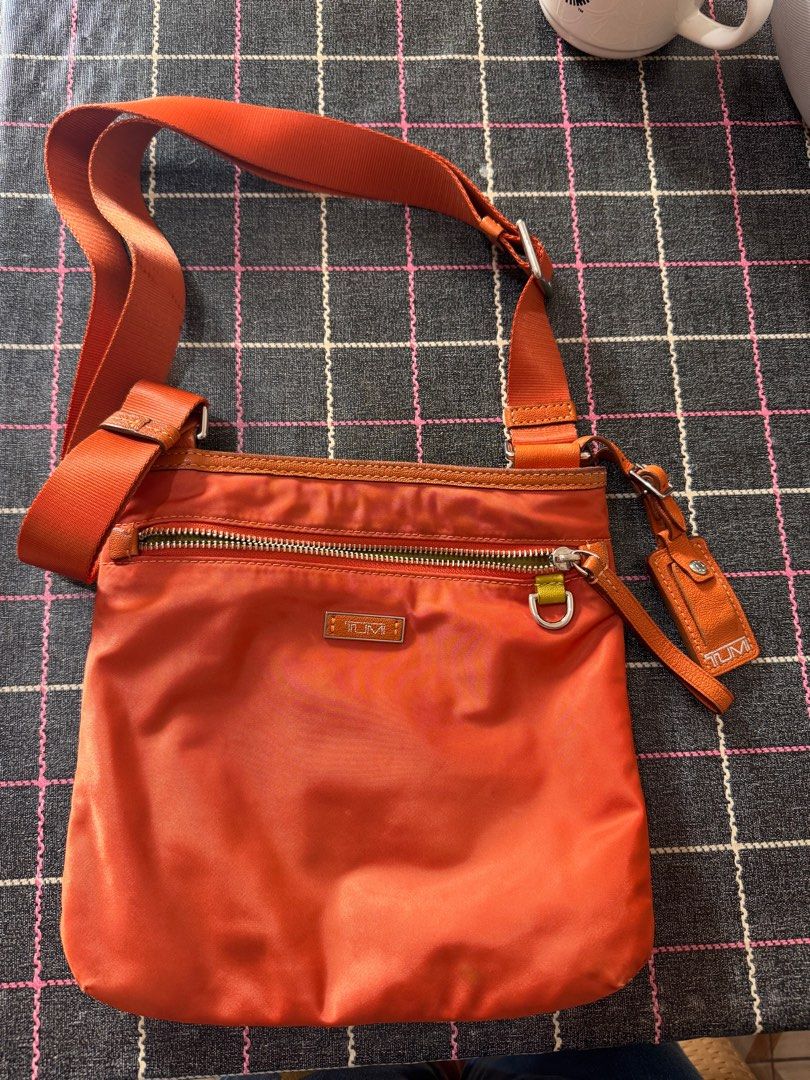 Tumi Tangerine Cross-body Bag (Category: Cross-body Bags) located in Paranaque City. Submitted by coralski (Listing ID 1346934587, Image 1). Description: 1 zippered pocket in front 1 open pocket at the back 1 zippered pocket and open pocket inside 2 key rings (inside and outside) Adjustable straps Needs cleaning, with stains.