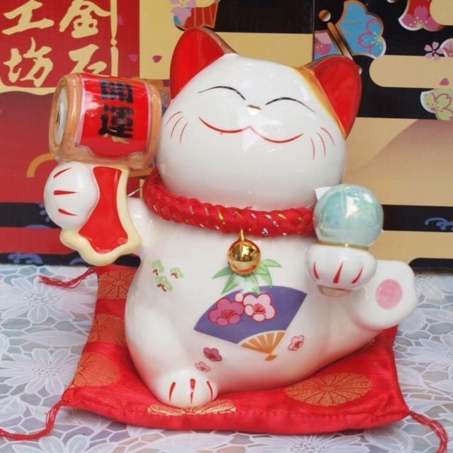 七福開運招財貓 SC53075 （分類：家居裝飾 - 其他）位於 Hong Kong。 由 tramps 提交（商品編號 1344971396，圖片 1）。簡介： 22 x 21.2 x 19.4 cm 767 g 寓意: 招財貓舉左手招財，象徵財源廣進，幸福到來；舉右手招福，招人緣，象徵客源絡繹不絕，人脈拓展。 相傳招財貓是在中國的唐代（酉陽雜俎）上所記載“正在洗臉的貓，將手高舉過耳的樣子，吸引著客人們前來”。日本最早的傳說則是在江戶初期（1658年左右），當時在江戶的世田谷有一個很窮的詩廟叫做（豪德寺），有一天寺廟裡的一個和尚，將自己的食物分給了一隻白貓，而吃了食物的白貓為了報恩，所以吸引了騎馬武士來到了廟裡，進到了廟里後，突然吹起了狂風暴雨，在無法離開的情況，武士們只好聽和尚們說佛法打發時間，沒想到佛法的內容卻感動了這群武士們，武士裡有一們是江州（彥根城）的城主姓“井伊”，因為這段姻緣，最後（豪德寺）就成為了井伊家的主寺廟一直繁榮至今，後來和尚們為了感念這隻貓，還幫他立了個墓，並取
