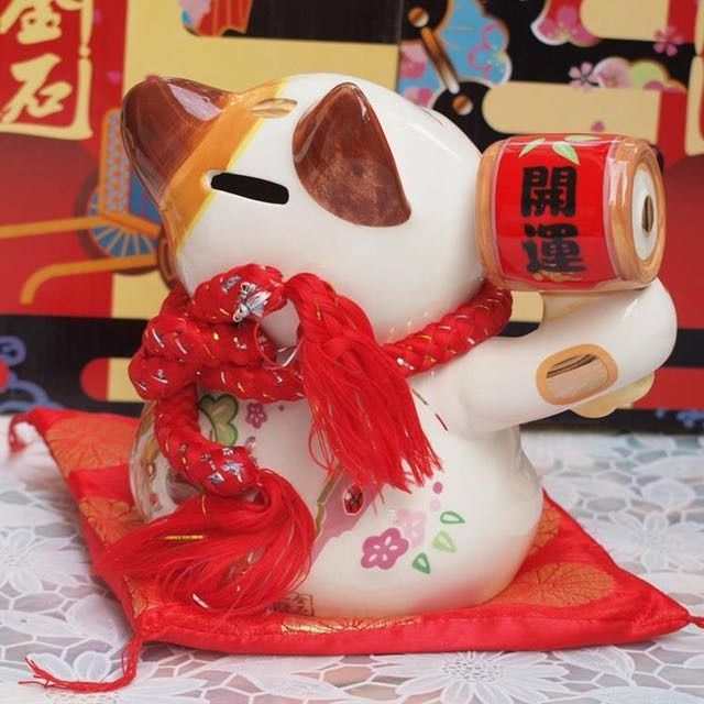 七福開運招財貓 SC53075 （分類：家居裝飾 - 其他）位於 Hong Kong。 由 tramps 提交（商品編號 1344971396，圖片 2）。簡介： 22 x 21.2 x 19.4 cm 767 g 寓意: 招財貓舉左手招財，象徵財源廣進，幸福到來；舉右手招福，招人緣，象徵客源絡繹不絕，人脈拓展。 相傳招財貓是在中國的唐代（酉陽雜俎）上所記載“正在洗臉的貓，將手高舉過耳的樣子，吸引著客人們前來”。日本最早的傳說則是在江戶初期（1658年左右），當時在江戶的世田谷有一個很窮的詩廟叫做（豪德寺），有一天寺廟裡的一個和尚，將自己的食物分給了一隻白貓，而吃了食物的白貓為了報恩，所以吸引了騎馬武士來到了廟裡，進到了廟里後，突然吹起了狂風暴雨，在無法離開的情況，武士們只好聽和尚們說佛法打發時間，沒想到佛法的內容卻感動了這群武士們，武士裡有一們是江州（彥根城）的城主姓“井伊”，因為這段姻緣，最後（豪德寺）就成為了井伊家的主寺廟一直繁榮至今，後來和尚們為了感念這隻貓，還幫他立了個墓，並取