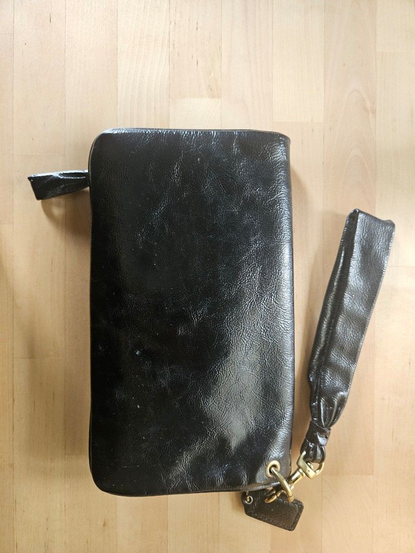 Coach black patent leather clutch (Category: Clutches) located in Taguig. Submitted by tikayiyay (Listing ID 1349802576, Image 3). Description: coach black patent leather clutch. well-used. can fit a Samsung S23+. Shipping fee to be shouldered by buyer. Payment: Gcash, Maya or BDO.