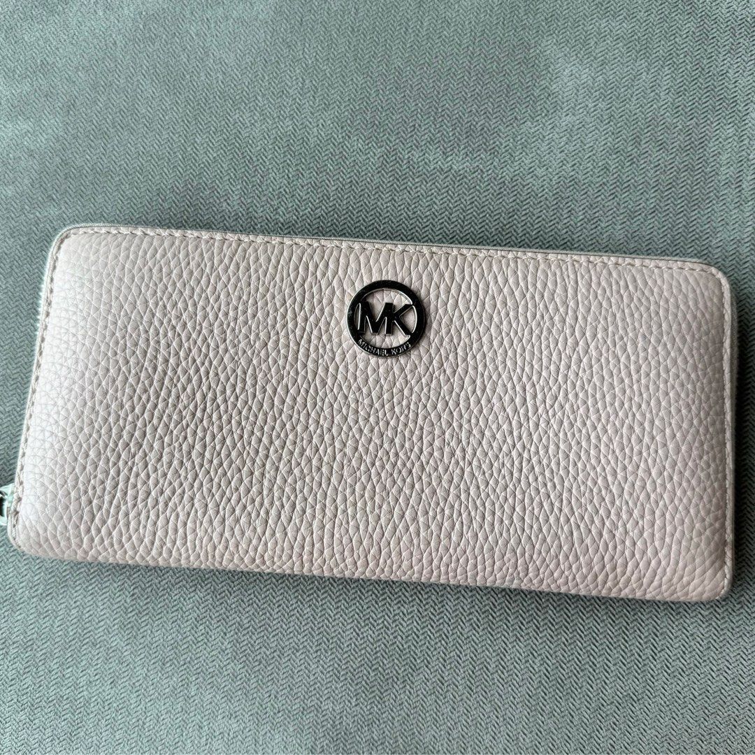 Michael Kors MK Blush Long Wallet (Preloved) (Category: Luxury Bags & Wallets) located in Quezon City. Submitted by __J__ (Listing ID 1350130945, Image 1). Description: Preloved original Michael Kors pebbled leather zip around long wallet. The interior is lined with Michael Kors signature lining. There are 8 small credit card slots, 2 large slip pockets on each side, and a coins zipper pocket. Approximately 8”l x 4”h. Condition: Used with care, w