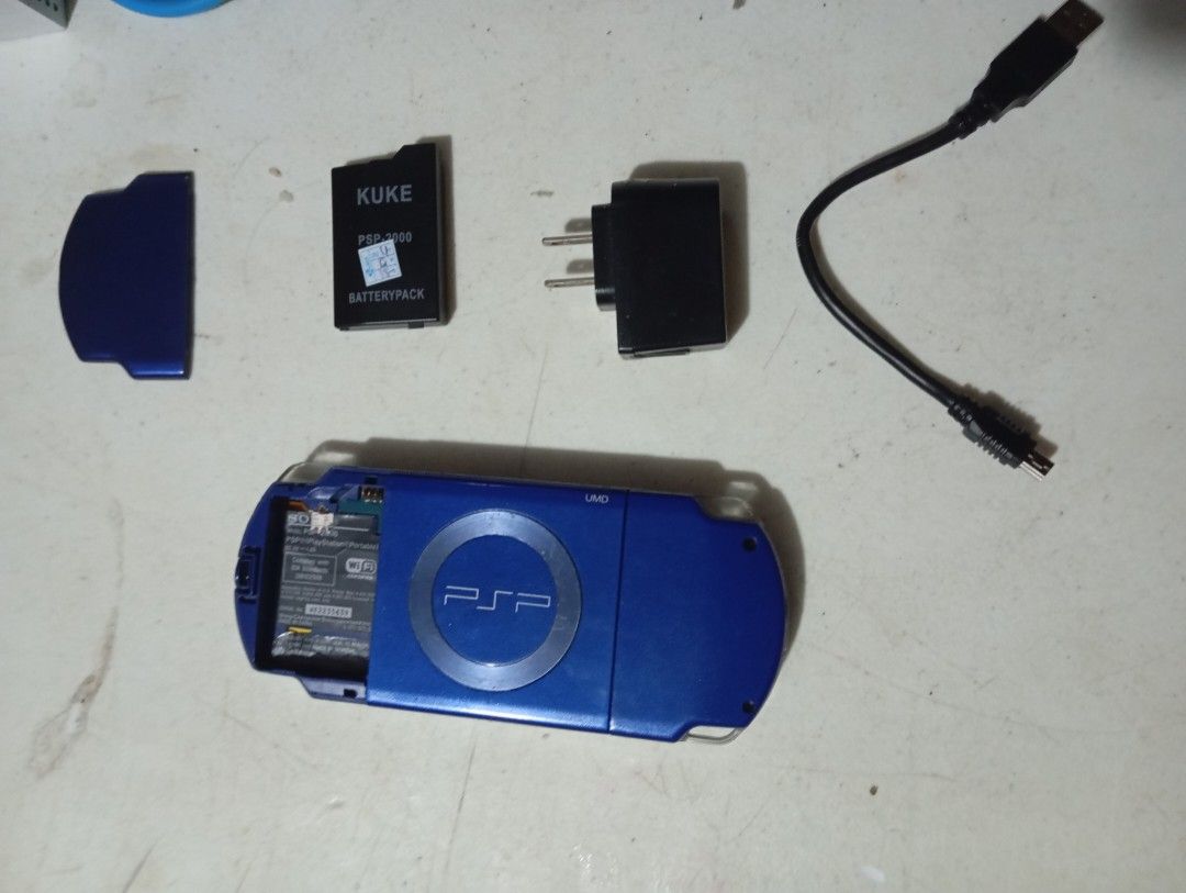PSP-2000 SLIM (With Problems) (Category: Other Gadgets) located in Manila. Submitted by espadaespa06124 (Listing ID 1345394182, Image 3). Description: PSP-2000 Slim Blue Variant Included: Battery (1200mAh) Battery Cover Mini B Data Cable Charger Brick Memory Stick Pro Duo (8 GB) Add On: AC Adaptor (100 PHP) Issues: Joystick drift and shoulder buttons broken, physical damage such as dents and scratches. Delivery: J&T Express.