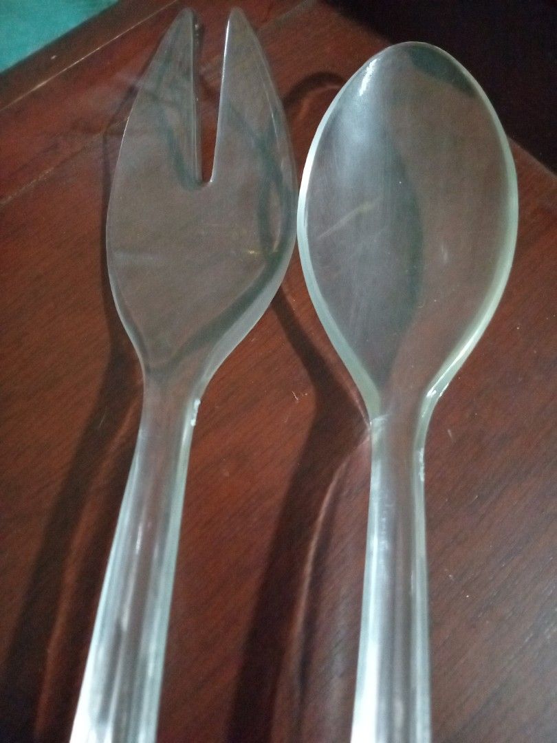 Clear Salad Serving Spoon and Fork (Category: Dinnerware & Cutlery) located in Valenzuela. Submitted by consjavier74 (Listing ID 1395803214, Image 2). Description: - Clear salad serving spoon and fork set - Made of clear, possibly acrylic material - Long, slender handles - Wide serving ends - Fork has two tines - Ideal for serving salads and other dishes.