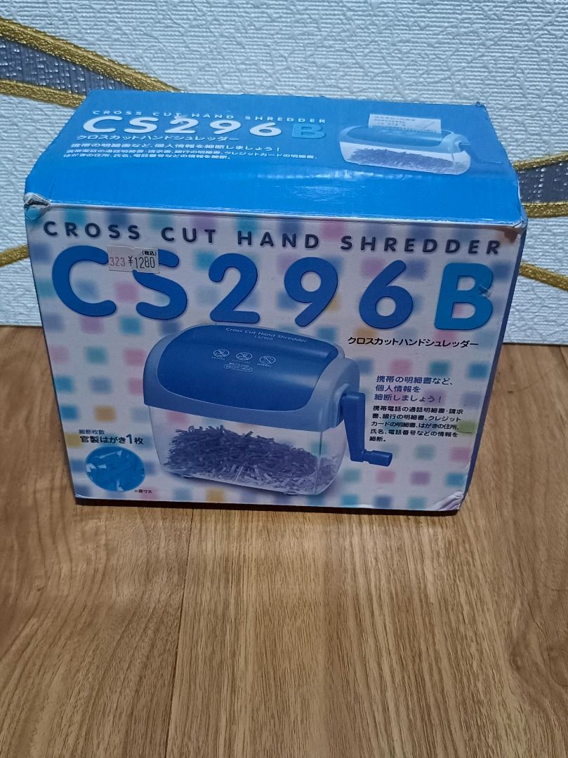 CS296B Cross Cut Hand Shredder (Category: Office & Business Technology) located in Makati City. Submitted by nyxhemera26 (Listing ID 1395915878, Image 2). Description: - CS296B Manual Cross-Cut Paper Shredder - Features a blue and clear plastic body - Operated with a hand crank - Designed for personal use - Shreds paper into small, secure pieces - Box shows design and features.