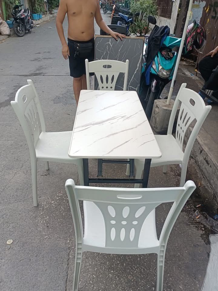 Dining Table Set with 4 Chairs (Category: Tables & Sets) located in Quezon City. Submitted by joycemanahan (Listing ID 1395846615, Image 2). Description: - Durable dining set - Rectangular table with marble-like surface - Includes four plastic chairs - Available colors: Black and White - Ideal for small spaces and apartments - Great for everyday use Quezon city location Cash on delivery 09197697979.