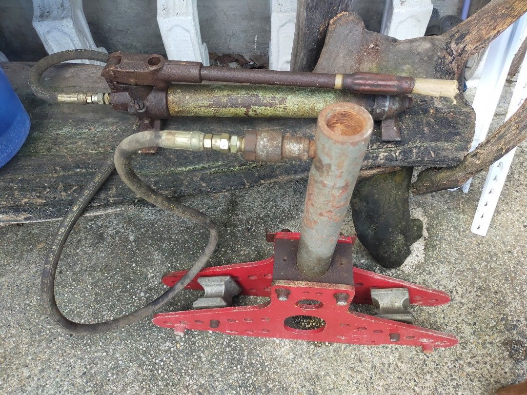 Hydraulic Pipe Bender (Category: Construction Tools & Equipment) located in Taytay. Submitted by archie2427 (Listing ID 1395893307, Image 2). Description: - Hydraulic pipe bender for bending pipes. - Features a sturdy red base with multiple holes. - Includes a central support and hydraulic pump. - Comes with connecting hoses. - Designed for heavy-duty use. - As is - For restoration or maybe repair.