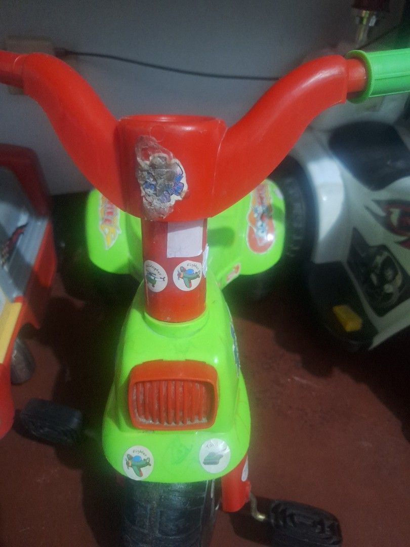 Kids Tricycle (Category: Motorbikes for Sale) located in Manila. Submitted by elboh79270 (Listing ID 1395812330, Image 1). Description: Tricycle features a green and red color scheme. It has a handle for steering and pedals for the child to use. The tricycle has some stickers on it. The wheels are black..