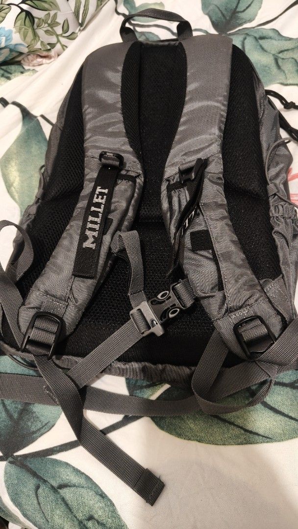 Millet Backpack (Category: Backpacks) located in Tanza. Submitted by declutterolshoppe (Listing ID 1395918113, Image 2). Description: - Durable Millet backpack - Dark grey color - Multiple compartments (front and side pockets) - Padded back support - Adjustable straps - Top handle for easy carrying - Millet logo visible.