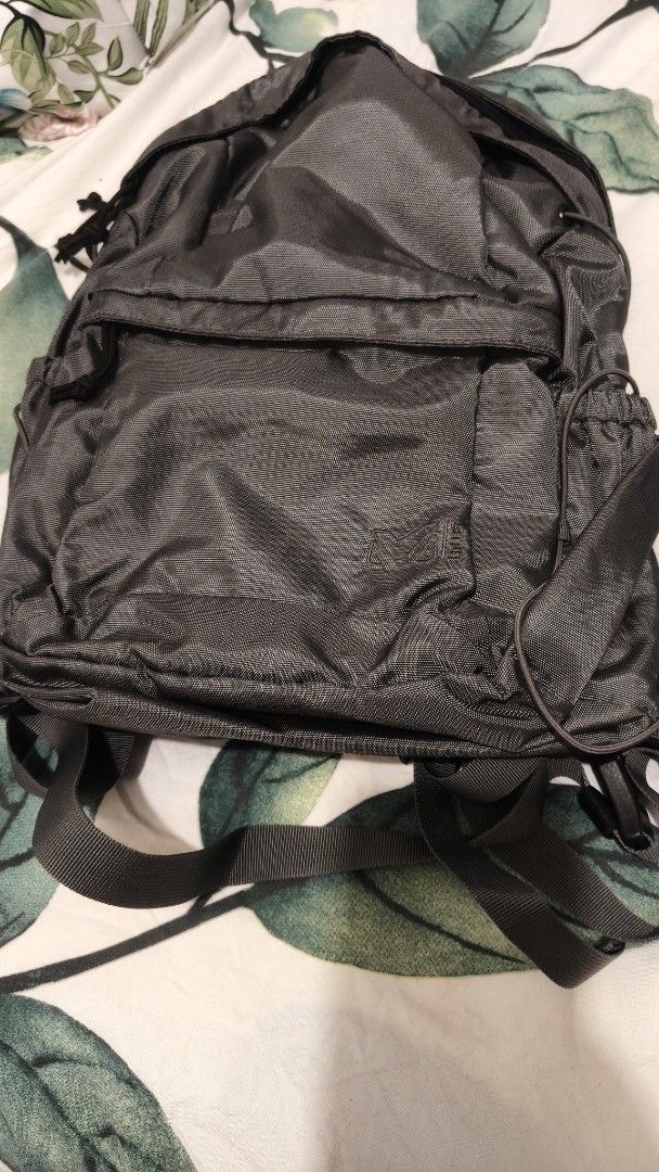 Millet Backpack (Category: Backpacks) located in Tanza. Submitted by declutterolshoppe (Listing ID 1395918113, Image 1). Description: - Durable Millet backpack - Dark grey color - Multiple compartments (front and side pockets) - Padded back support - Adjustable straps - Top handle for easy carrying - Millet logo visible.