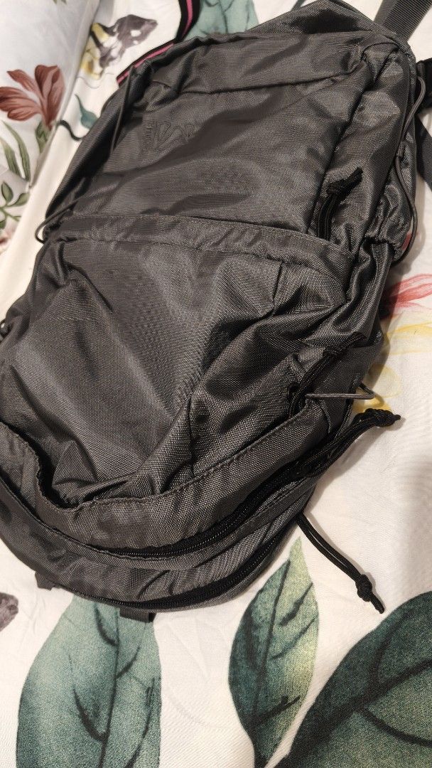 Millet Backpack (Category: Backpacks) located in Tanza. Submitted by declutterolshoppe (Listing ID 1395918113, Image 3). Description: - Durable Millet backpack - Dark grey color - Multiple compartments (front and side pockets) - Padded back support - Adjustable straps - Top handle for easy carrying - Millet logo visible.