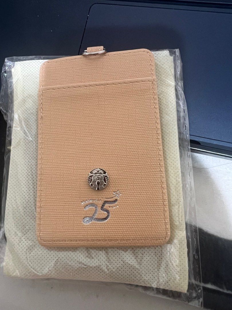 Starbucks 25th Anniversary Card Holder (Category: Wallets & Card holders) located in San Fernando. Submitted by leonag (Listing ID 1395892145, Image 1). Description: - Starbucks 25th Anniversary Card Holder - Special Edition - Beige color - Includes lanyard - Comes with a pouch - Features Starbucks logo and anniversary details - Brand new, in original packaging.