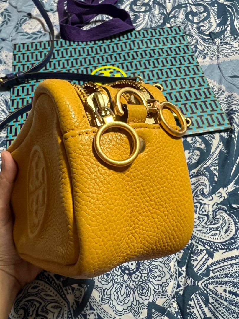 Tory Burch Perry Bombe Mini (Category: Luxury Bags & Wallets) located in Las Pinas. Submitted by anakim (Listing ID 1395747488, Image 3). Description: - Authentic Tory Burch Perry Bombe Mini crossbody bag - Color: Mustard Yellow - Features: Front pocket, dual zipper closure, embossed logo - Includes: Detachable crossbody strap, dustbag, paper bag - Interior: Lined with matching yellow fabric - Made in the Philippines.