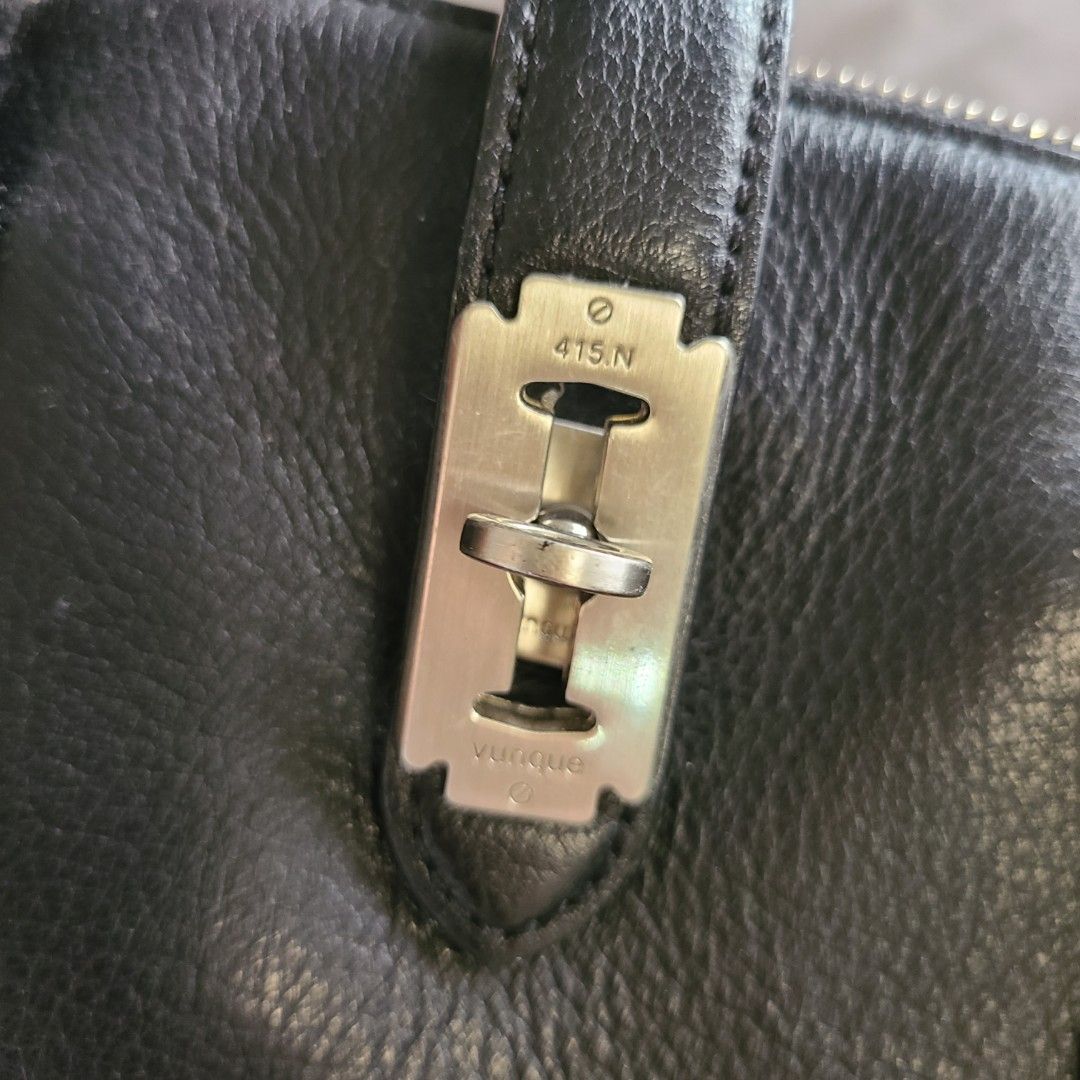 Vunque Toque Halfmoon Black Handbag (Category: Luxury Bags & Wallets) located in Santa Rosa. Submitted by girlgloss (Listing ID 1395788577, Image 3). Description: - Black leather handbag - Top handle - Zip closure - Silver-tone lock detail - rubber lining perfect condition - Light-colored interior lining - Brand tag inside - Structured shape - excellent leather and hardware condition - needs cleaning inside - no strap.