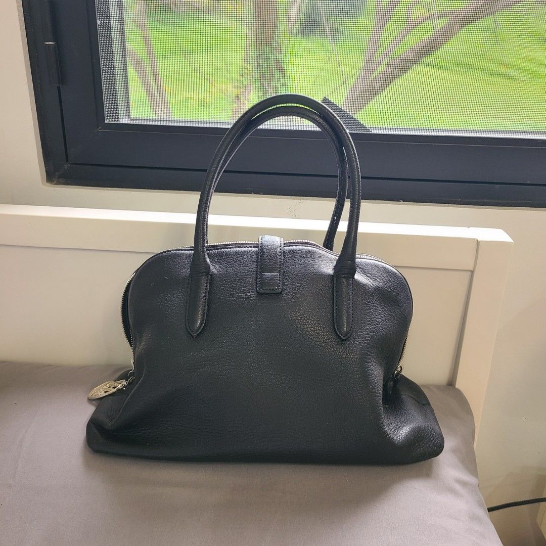 Vunque Toque Halfmoon Black Handbag (Category: Luxury Bags & Wallets) located in Santa Rosa. Submitted by girlgloss (Listing ID 1395788577, Image 2). Description: - Black leather handbag - Top handle - Zip closure - Silver-tone lock detail - rubber lining perfect condition - Light-colored interior lining - Brand tag inside - Structured shape - excellent leather and hardware condition - needs cleaning inside - no strap.
