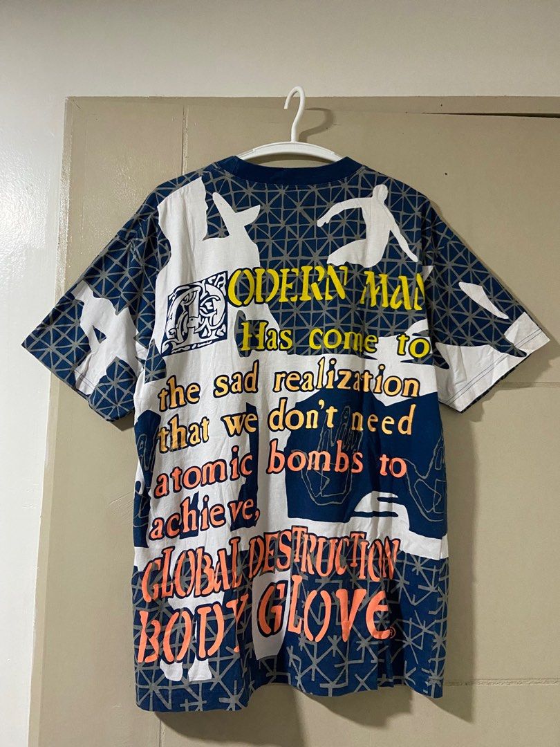 Body Glove Modern Man Graphic Tee (Category: Tshirts & Polo Shirts ) located in Binan City. Submitted by doze16 (Listing ID 1397447342, Image 2). Description: Vintage Body Glove graphic tee featuring a unique "Modern Man" design. It has a crew neck and short sleeves. The shirt is size M, with measurements of 22x29. There are some minor imperfections, including a small tear near the collar and a small hole on the graphic. Made in Taiwan..
