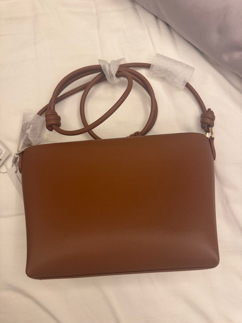 Charles & Keith Tan Crossbody Bag (Category: Cross-body Bags) located in Makati City. Submitted by masaca (Listing ID 1397536995, Image 3). Description: - Charles & Keith crossbody bag - Color: Tan - Unique envelope design with white accent - Features a zip closure - Includes a long strap - Size: S - Brand new with original tags.
