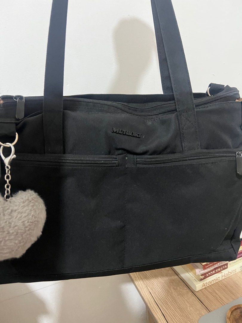 Muroki Black Tote Bag with Charm (Category: Tote Bags) located in Cabanatuan. Submitted by didicstll (Listing ID 1397531398, Image 3). Description: - Muroki black tote bag - Multiple zippered compartments - Long shoulder straps - Includes heart-shaped charm - Patterned interior lining - Durable and possibly water-resistant material - Ideal for everyday use.