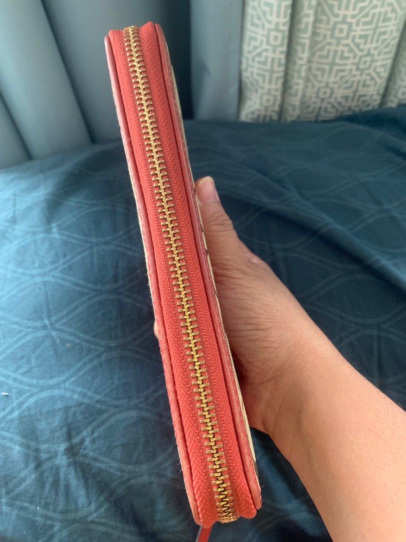 Original Coach Wallet (Category: Luxury Bags & Wallets) located in Quezon City. Submitted by shopersville (Listing ID 1397460084, Image 3). Description: - Original Coach signature canvas wallet - Stylish coral stripe detail - Rich red leather interior - Multiple card slots for organization - Convenient zippered coin pocket - Elegant gold-tone hardware and zipper - Includes original Coach gold charm - Flaw: Gold charm is a little bit tarnished but
