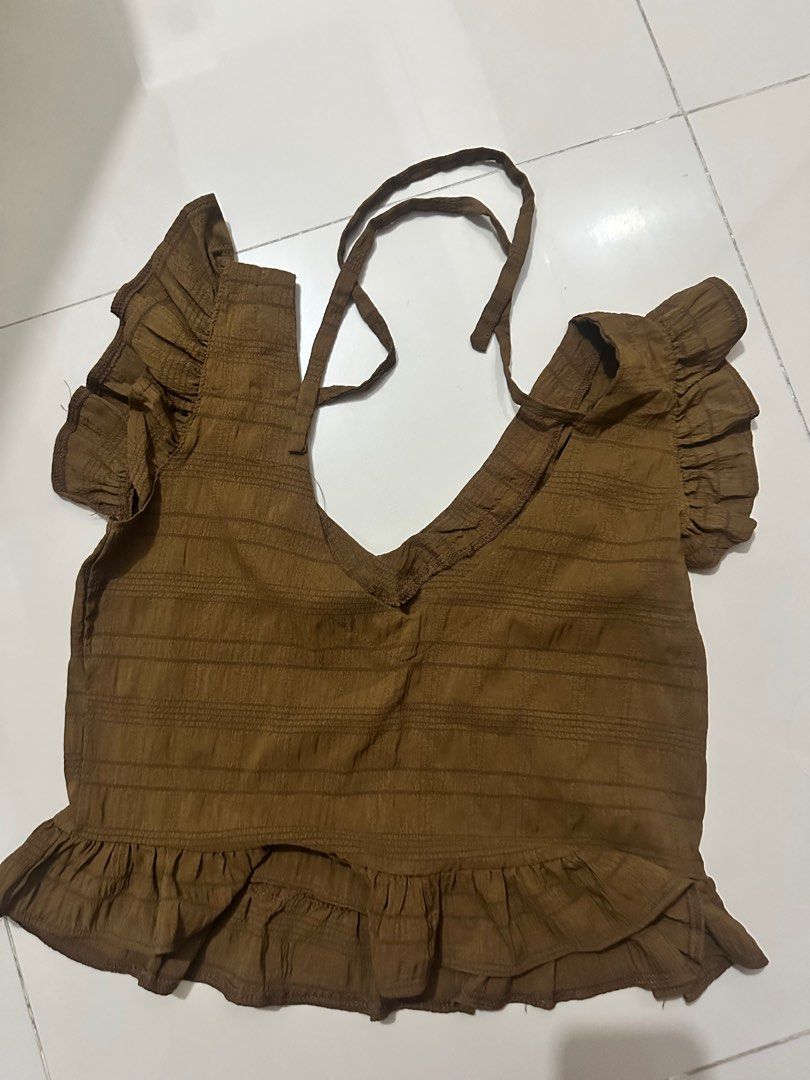 Ruffle Top (Category: Sleeveless) located in Manila. Submitted by cazly (Listing ID 1397538245, Image 2). Description: - Stylish ruffle top - Flattering V-neck - Unique back tie detail - Ruffled hem and sleeves - Perfect for a casual chic look - Available colors: Brown, Mint Green.