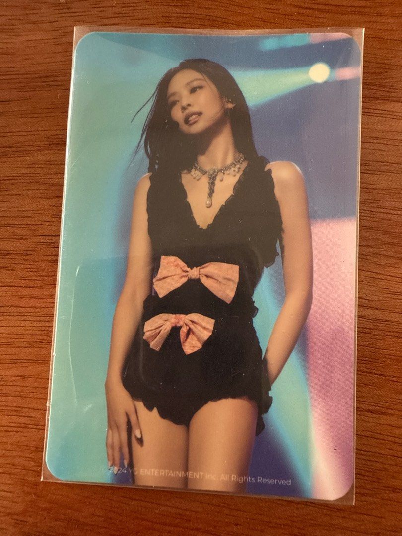 Blackpink Jennie Photocard (Category: K-Wave Merchandise) located in Quezon City. Submitted by rxhanne (Listing ID 1397599307, Image 1). Description: - Jennie Blackpink photocard - Features Jennie in a black outfit - Includes two pink bows - Comes with a protective sleeve - Background: Blue and pink gradient - YG Entertainment logo visible.