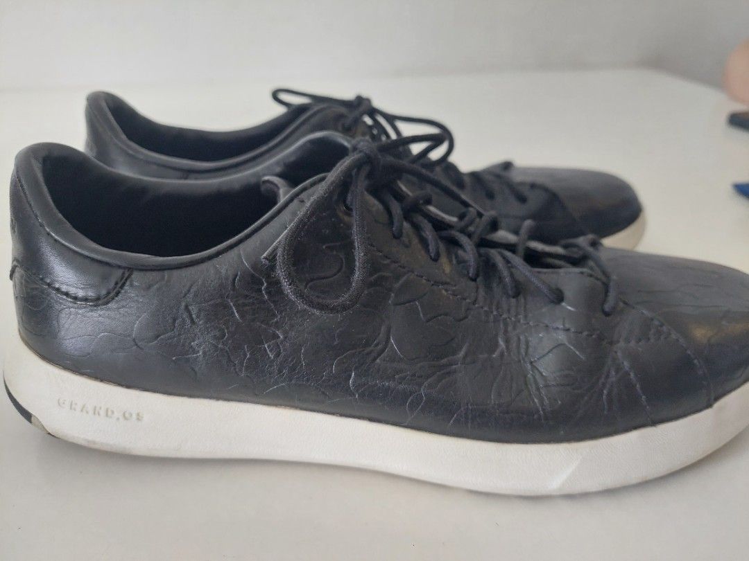 Cole Haan Black Leather Sneakers (Category: Sneakers) located in Pasig City. Submitted by warrenroyo (Listing ID 1397640911, Image 3). Description: - Cole Haan sneakers - Black leather upper - White soles - Textured design - Lace-up closure - Some sole wear - Casual wear.