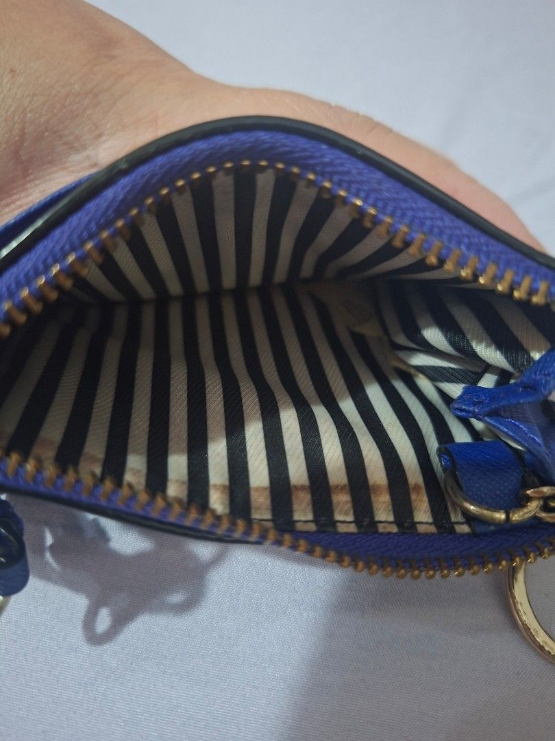 Kate Spade Cardholder (Category: Wallets & Card holders) located in Paranaque City. Submitted by chebureche (Listing ID 1397586632, Image 3). Description: - Kate Spade cardholder - Vibrant blue color - Zip closure - Wrist strap - Gold-tone keyring - Striped fabric lining - Multiple card slots - Clear ID window - 100% cow leather - Minor wear and tear on edges.