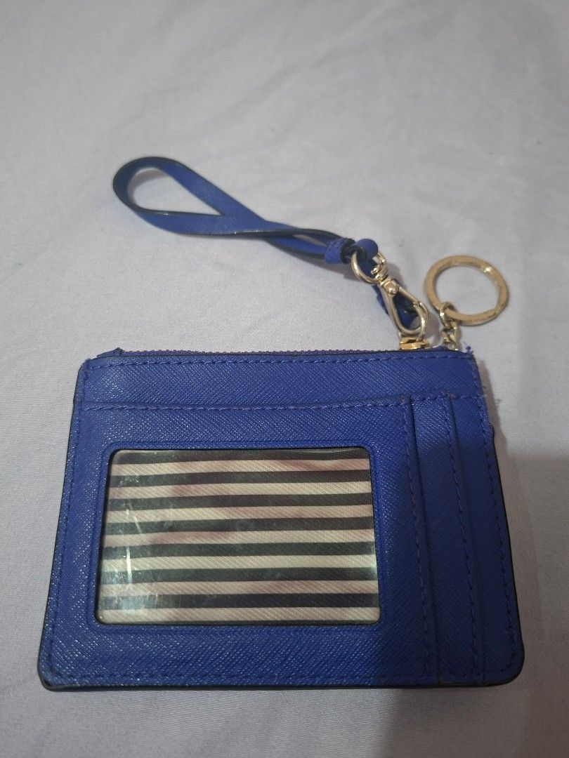 Kate Spade Cardholder (Category: Wallets & Card holders) located in Paranaque City. Submitted by chebureche (Listing ID 1397586632, Image 2). Description: - Kate Spade cardholder - Vibrant blue color - Zip closure - Wrist strap - Gold-tone keyring - Striped fabric lining - Multiple card slots - Clear ID window - 100% cow leather - Minor wear and tear on edges.