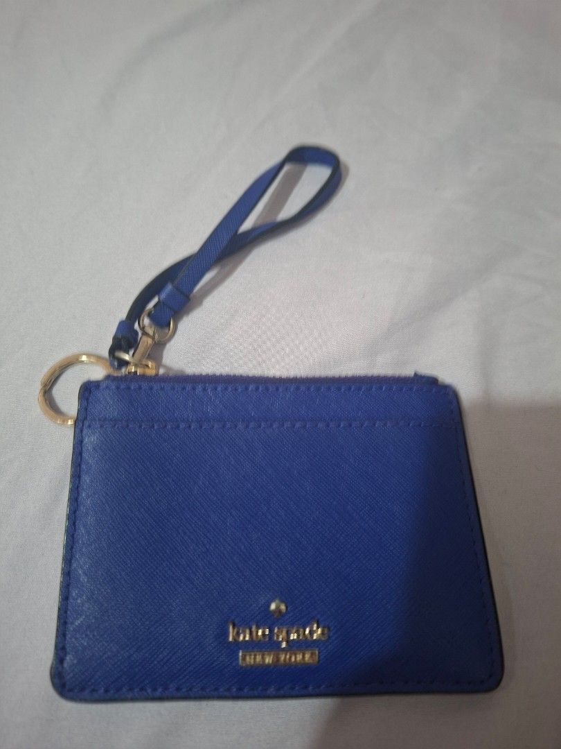 Kate Spade Cardholder (Category: Wallets & Card holders) located in Paranaque City. Submitted by chebureche (Listing ID 1397586632, Image 1). Description: - Kate Spade cardholder - Vibrant blue color - Zip closure - Wrist strap - Gold-tone keyring - Striped fabric lining - Multiple card slots - Clear ID window - 100% cow leather - Minor wear and tear on edges.