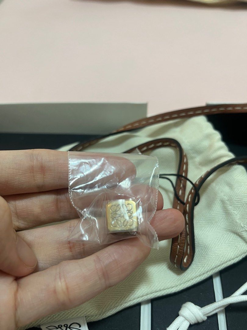 Loewe Leather Strap Anagram Tan/Gold (Category: Luxury Bags & Wallets) located in San Juan City. Submitted by mnatividad (Listing ID 1397713783, Image 3). Description: -Loewe leather strap -Color: Tan/Gold - Includes: Box, Small pouch, charm, original box - Strap Details: Brown/Tan with knot detail .