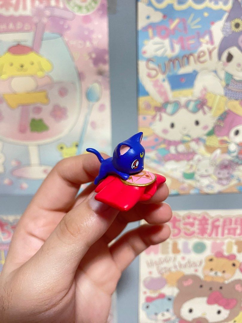 Sailor Moon Luna Cat Figure Cable Bite (Category: Figurines & Statues) located in Muntinlupa City. Submitted by matchalinlin (Listing ID 1397602888, Image 2). Description: - Adorable Luna cat figurine from Sailor Moon! - Features Luna in her iconic blue color. - Sitting comfortably on a red cushion. - Small and highly detailed. - Ideal for display or as a desk accessory. - A great addition to any Sailor Moon collection!.