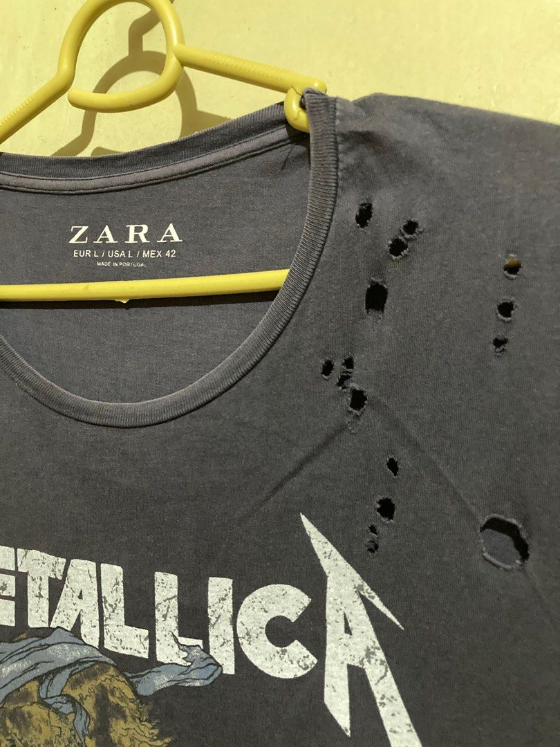 Zara Metallica distressed Style Tee (Category: Tshirts & Polo Shirts ) located in Caloocan City. Submitted by binsbinss (Listing ID 1397637295, Image 2). Description: - Zara Metallica graphic t-shirt - Dark gray color - Size L - Distressed design with holes on the upper left shoulder.
