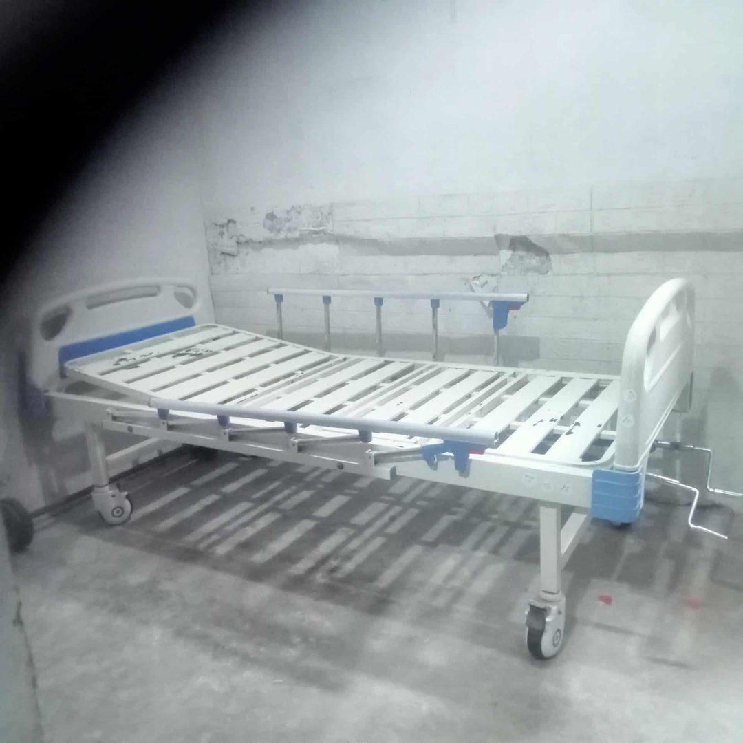 Adjustable Hospital Bed with Wheels (Category: Medical Supplies & Tools) located in Valenzuela. Submitted by happycouture (Listing ID 1397779295, Image 1). Description: - Adjustable hospital bed - White frame with blue accents - Slatted bed frame - Adjustable head and foot sections - Crank mechanism for height adjustment - Wheels for easy movement - Suitable for home or clinical use.