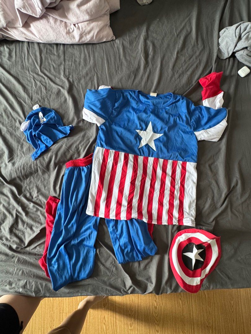 Captain America Costume Set (Category: Coats, Jackets and Outerwear) located in Mandaluyong City. Submitted by cris333 (Listing ID 1397914791, Image 2). Description: - Complete Captain America costume set. - Includes: top, pants, hat, and shield. - Top: Blue with white star and red/white stripes. - Pants: Blue with red cuffs. - Hat: Features the letter "A". - Shield: Red, white, and blue with a white star..
