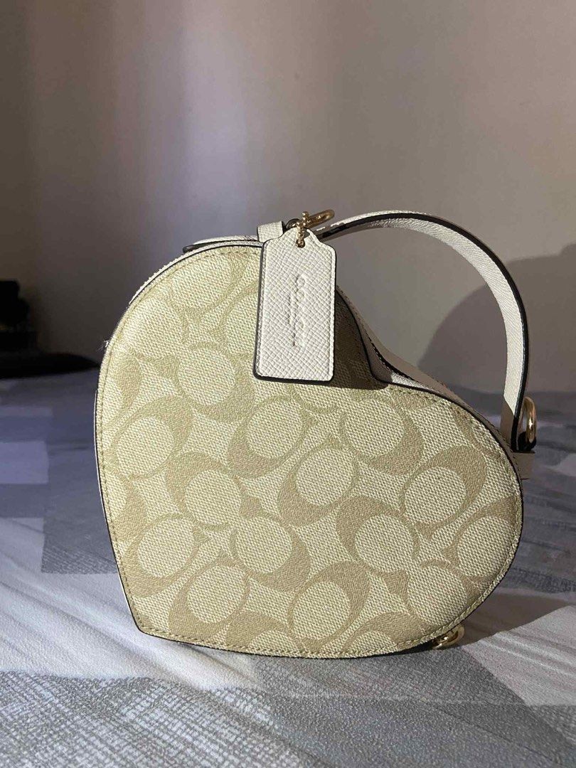 Coach Heart-Shaped Bag (Category: Luxury Bags & Wallets) located in Iba. Submitted by gotmethrift (Listing ID 1397883585, Image 1). Description: - Authentic Coach bag - Unique heart shape - Signature Coach pattern - Top handle - Zip closure - Made in Vietnam - Gold-toned hardware - White trim - Includes Coach tag - Coach interior label.