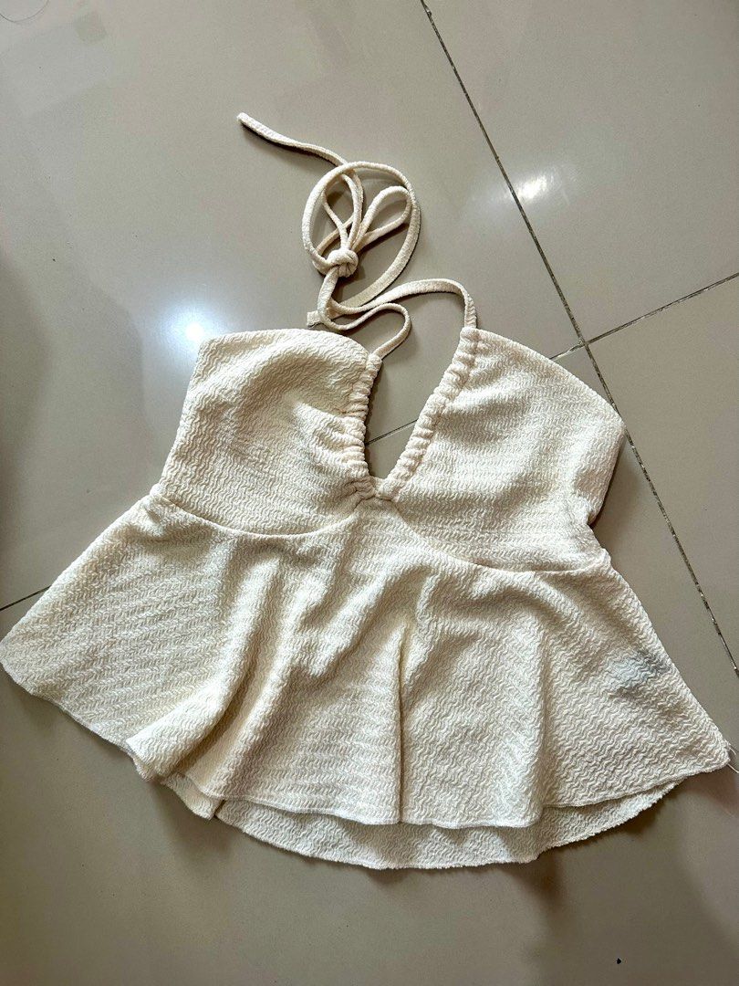Cream Halter Top (Category: Sleeveless) located in Manila. Submitted by cazly (Listing ID 1397847729, Image 2). Description: - Cream-colored halter top - Textured fabric - V-neckline - Flared hem - Tie-up halter neck - Sleeveless design - Ideal for warm weather.