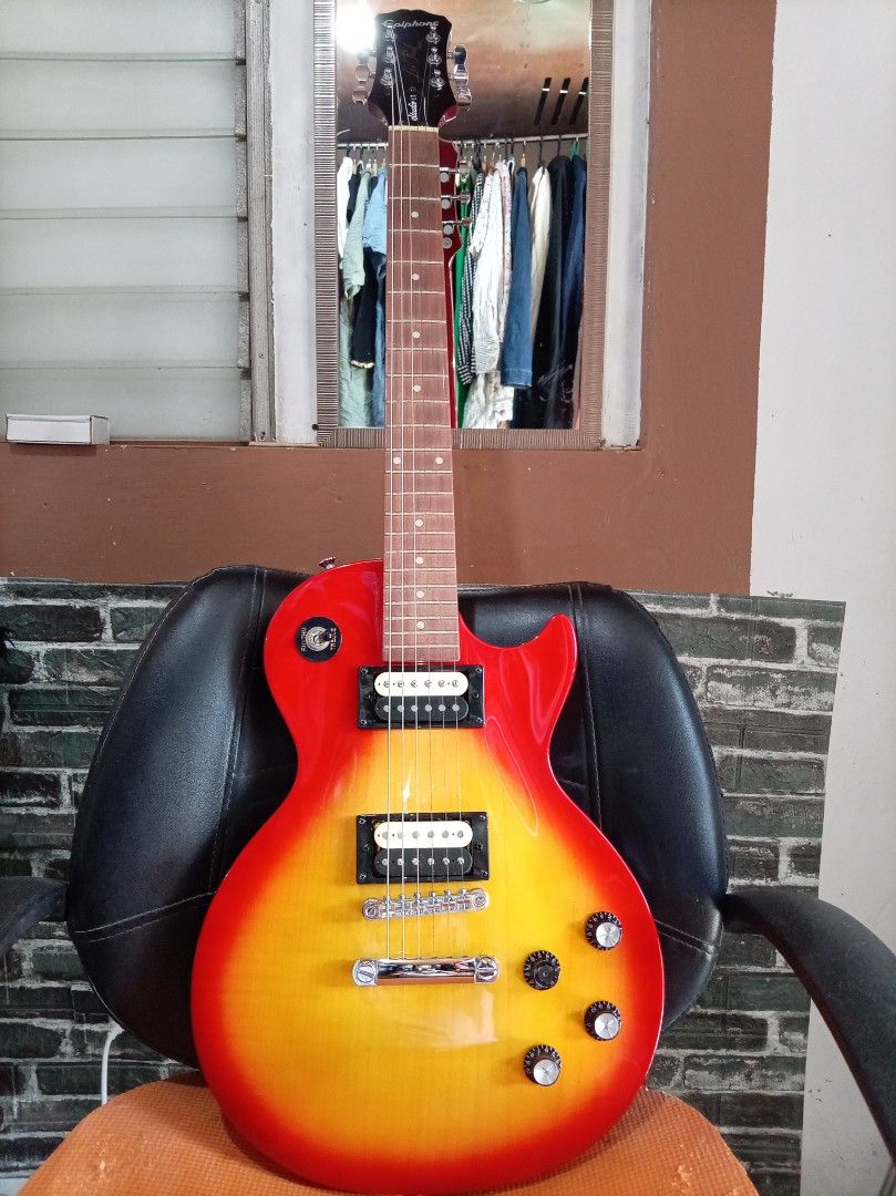 Epiphone Les Paul Studio LT Electric Guitar (Category: Musical Instruments) located in Agdangan. Submitted by hairulmusicalcolection (Listing ID 1397825726, Image 1). Description: - Epiphone Les Paul Studio LT electric guitar - Eye-catching red and yellow finish - Features two humbucker pickups - Classic Les Paul body shape - Volume and tone controls - Epiphone logo and Les Paul Studio LT model on headstock.
