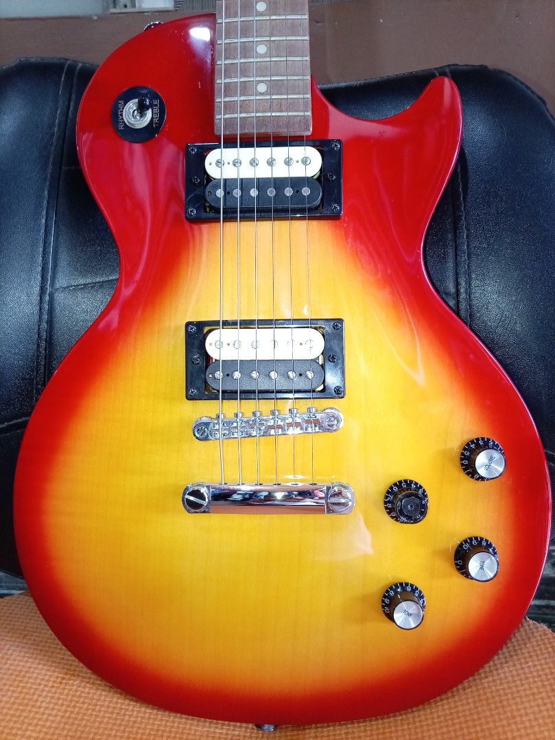 Epiphone Les Paul Studio LT Electric Guitar (Category: Musical Instruments) located in Agdangan. Submitted by hairulmusicalcolection (Listing ID 1397825726, Image 2). Description: - Epiphone Les Paul Studio LT electric guitar - Eye-catching red and yellow finish - Features two humbucker pickups - Classic Les Paul body shape - Volume and tone controls - Epiphone logo and Les Paul Studio LT model on headstock.