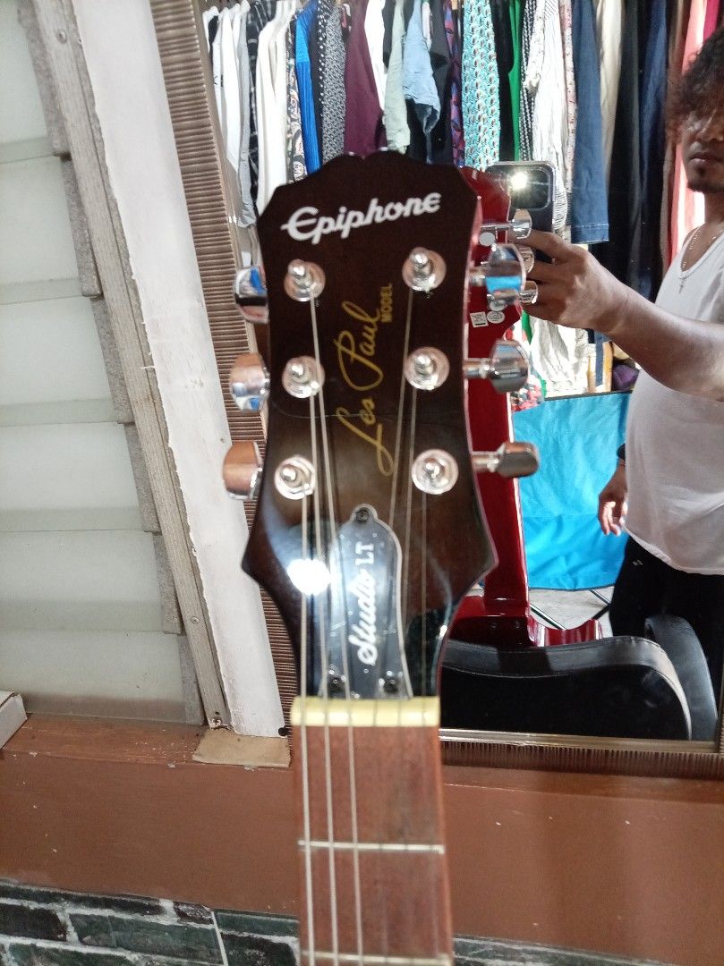 Epiphone Les Paul Studio LT Electric Guitar (Category: Musical Instruments) located in Agdangan. Submitted by hairulmusicalcolection (Listing ID 1397825726, Image 3). Description: - Epiphone Les Paul Studio LT electric guitar - Eye-catching red and yellow finish - Features two humbucker pickups - Classic Les Paul body shape - Volume and tone controls - Epiphone logo and Les Paul Studio LT model on headstock.
