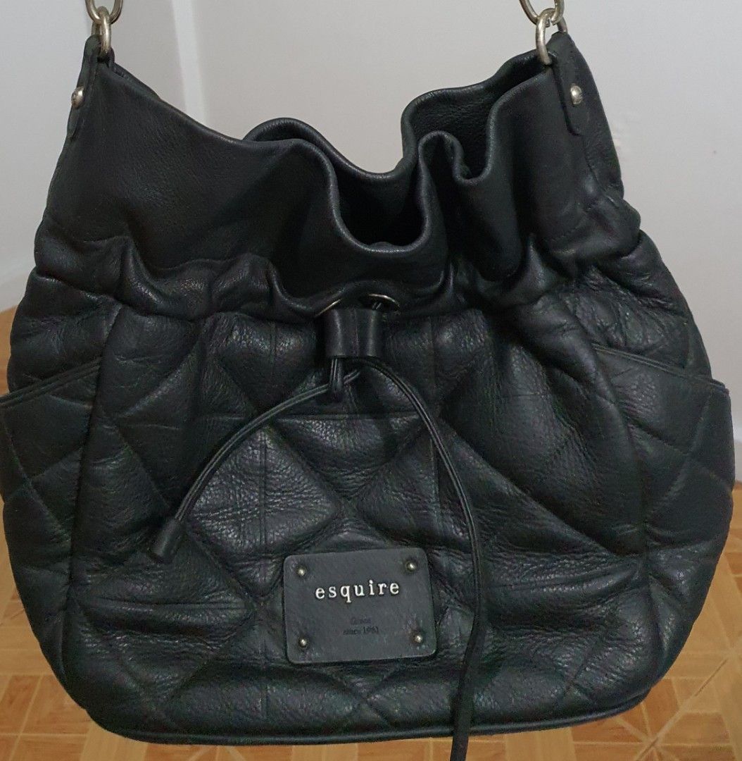 Esquire Black Quilted Shoulder Bag (Category: Shoulder Bags) located in Pasig City. Submitted by markieng (Listing ID 1397920602, Image 1). Description: - Black Esquire shoulder bag - Quilted design - Drawstring closure - Silver chain straps - Small exterior pocket - Rectangular brand tag - Made of leather.