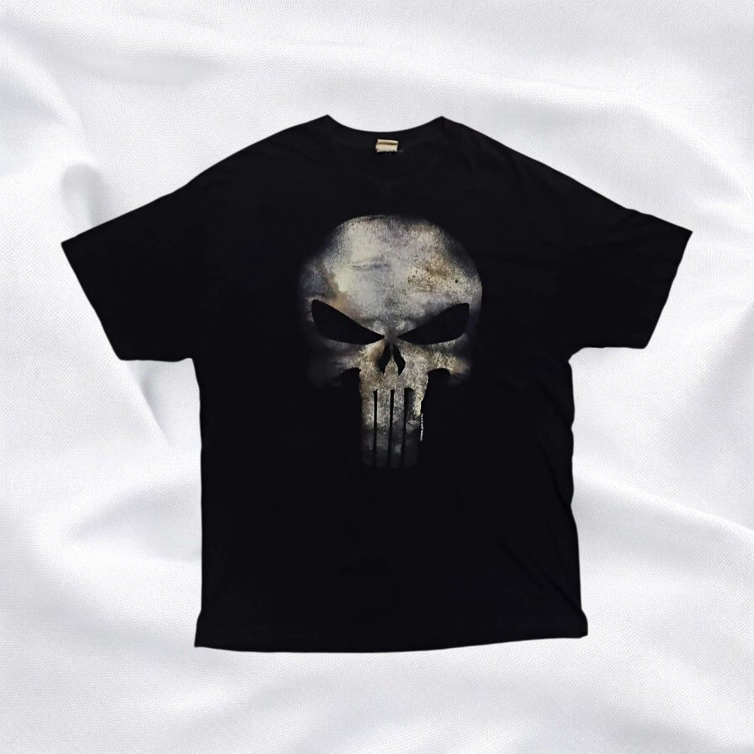 (GRAILED PIECE) MAD ENGINE Punisher, dated back to 2007. (Category: Tshirts & Polo Shirts ) located in Caloocan City. Submitted by dyn0zx (Listing ID 1397951649, Image 1). Description: (GRAILED PIECE) MAD ENGINE Punisher, dated back to 2007. Dimensions: Width: 24 Length: 32 This Punisher t-shirt features a striking, distressed graphic of the Punisher's skull logo in shades of grey, white, and subtle gold or tan, giving it a gritty, worn appearanc
