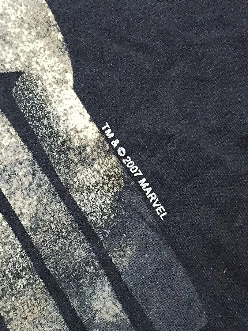 (GRAILED PIECE) MAD ENGINE Punisher, dated back to 2007. (Category: Tshirts & Polo Shirts ) located in Caloocan City. Submitted by dyn0zx (Listing ID 1397951649, Image 3). Description: (GRAILED PIECE) MAD ENGINE Punisher, dated back to 2007. Dimensions: Width: 24 Length: 32 This Punisher t-shirt features a striking, distressed graphic of the Punisher's skull logo in shades of grey, white, and subtle gold or tan, giving it a gritty, worn appearanc