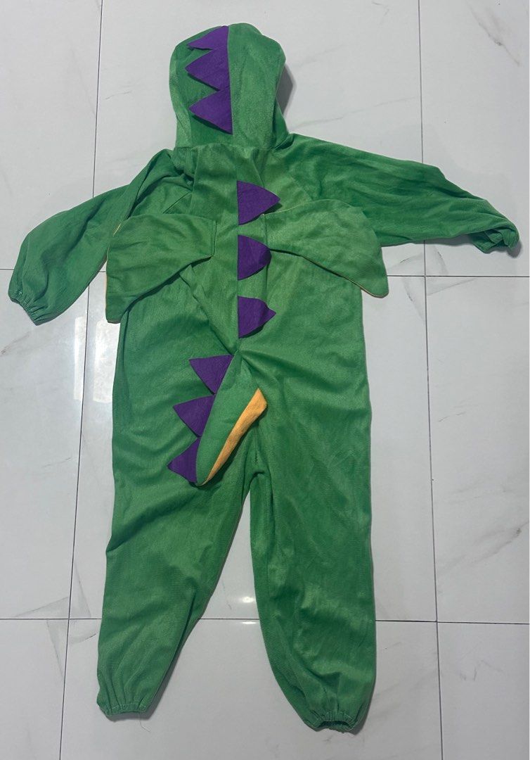 Green Dinosaur Costume with Hood (Category: Babies & Kids Fashion) located in Manila. Submitted by chamwel (Listing ID 1397788145, Image 2). Description: - Green dinosaur costume - Features a dinosaur face hood - Includes a yellow belly - Long sleeves and elastic cuffs - Purple spikes and tail detail - One-piece design - Zipper closure.