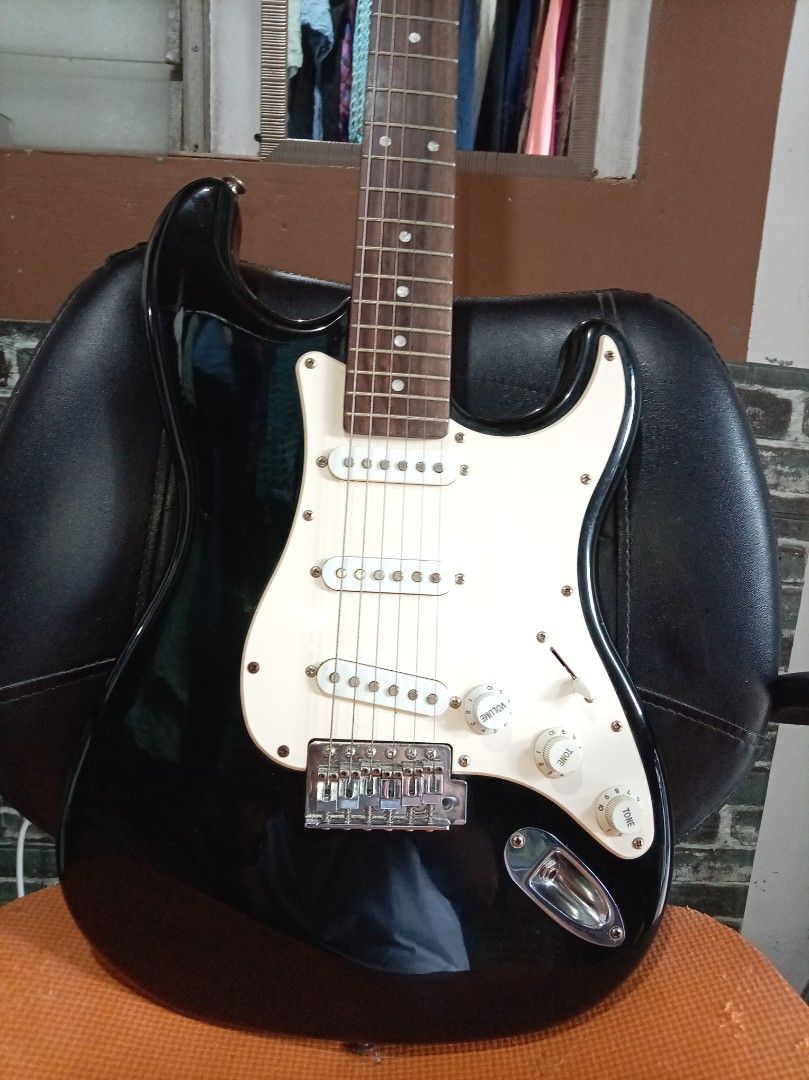 J&D Fender Electric Guitar (Category: Musical Instruments) located in Agdangan. Submitted by hairulmusicalcolection (Listing ID 1397828387, Image 2). Description: - Black J&D Fender electric guitar - White pickguard - Three single-coil pickups - Tremolo bridge - Maple neck - J&D Guitars logo on headstock - Six tuning pegs - Black body.