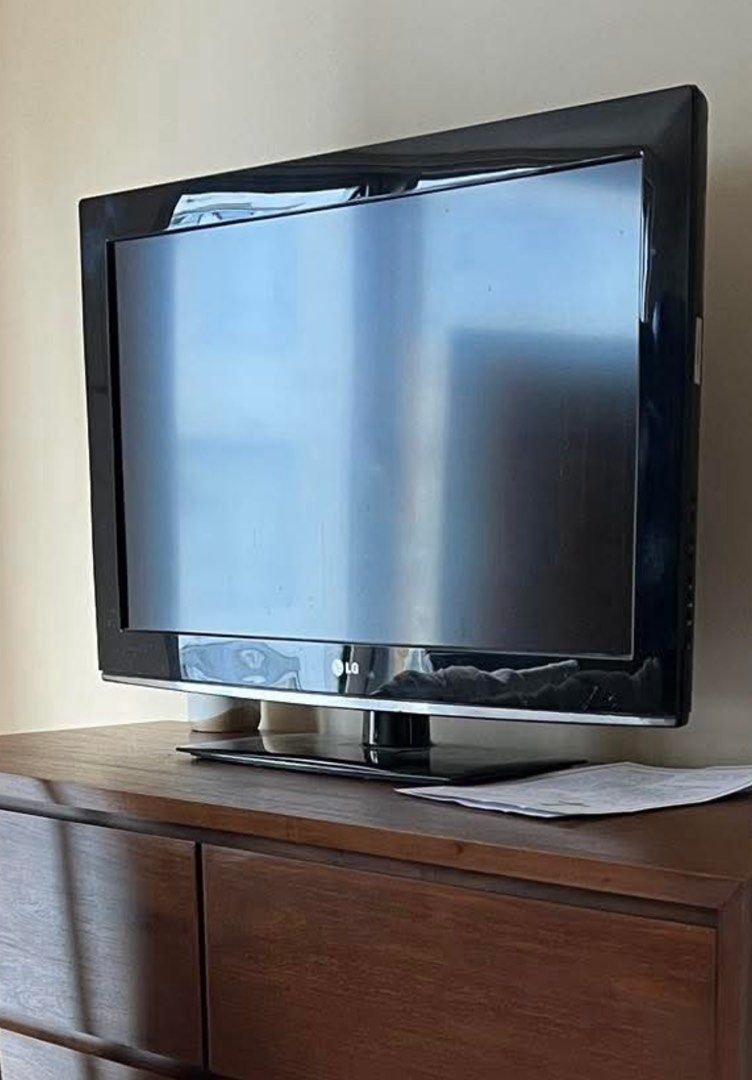 LG TV 32" (Category: TV) located in Makati City. Submitted by mommykars (Listing ID 1397962558, Image 3). Description: - LG TV with a black - Placed on a wooden dresser - Multiple ports and connections at the back - In good working condition - FREE XIAO MI Controller to make it smart TV for sure buyer .