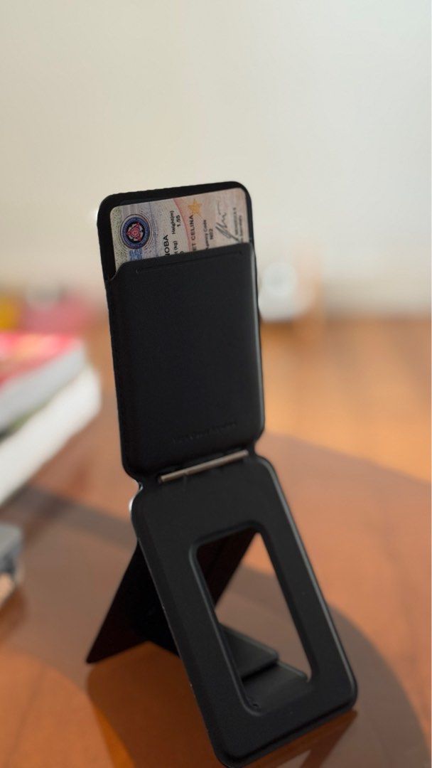 MOFT Snap-On Phone Stand and Wallet (Category: Mounts & Holders) located in Mandaluyong City. Submitted by jiadeclutters (Listing ID 1397811829, Image 2). Description: - MOFT Snap-On Phone Stand & Wallet - Black color - Magnetic design for easy attachment - Functions as a phone stand with multiple viewing angles - Integrated wallet for card storage (can fit up to 2 cards) .