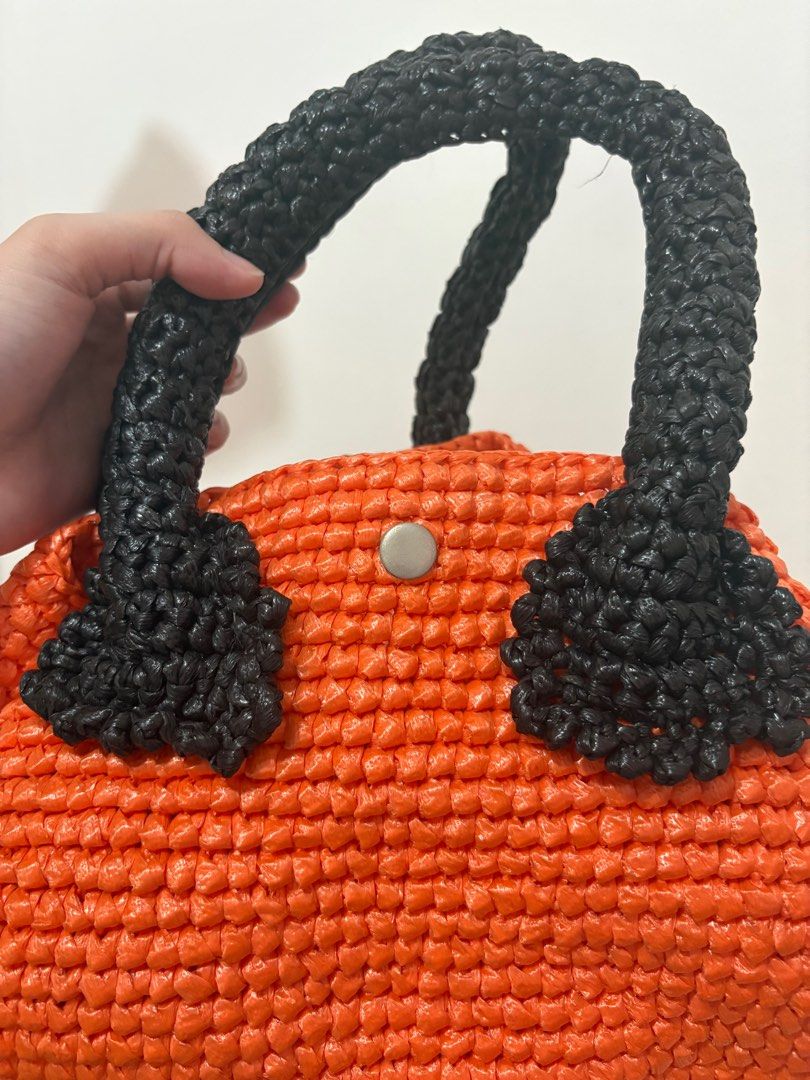 Orange Woven Handbag with Black Handles (Category: Luxury Bags & Wallets) located in Taguig. Submitted by mnom05 (Listing ID 1397940150, Image 3). Description: - Vibrant orange straw woven body - Contrasting black handles - Secure button closure - Spacious interior - Unique woven texture - Comfortable and sturdy handles - Ideal for daily essentials.